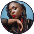 A profile picture of the influencer @nikkilynette. She rests her tilted head on her wrist and wears long, ornate earrings.